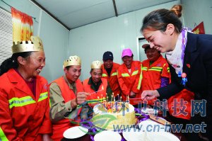 社區(qū)工作人員為集體過生日的三名環(huán)衛(wèi)工人點上生日蠟燭。 本報通訊員 趙松 攝